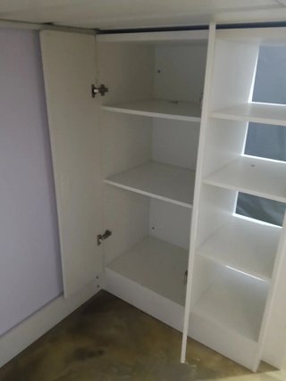 Cama alta blanca con estanterías