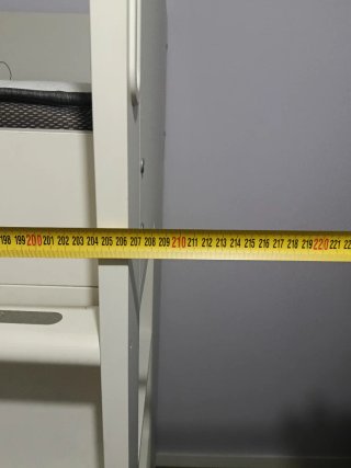 Cama alta blanca con estanterías