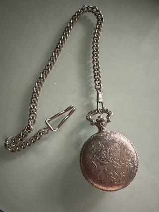Reloj de bolsillo plateado con cadena
