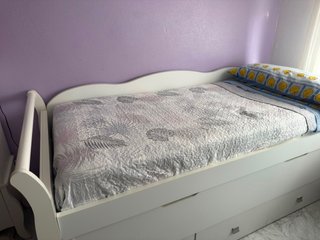 Cama blanca con cajones y estantería