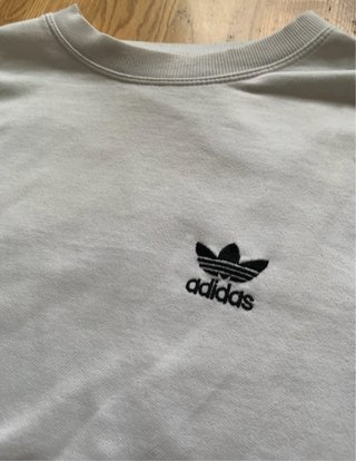 Sudadera Adidas blanca con rayas sin capucha.