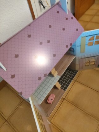 Casa de muñecas rosa con tejado de escamas