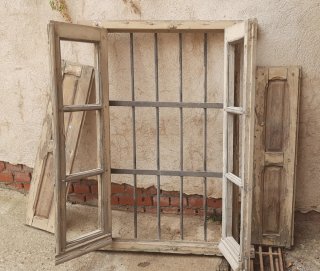Ventanal antiguo de madera con reja.