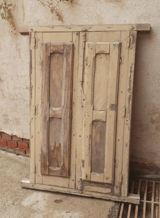 Ventanal antiguo de madera con reja.