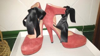 Zapatos de tacón rojos con lazo negro