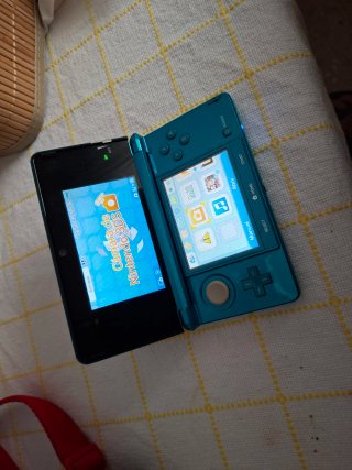 Nintendo 3DS Aqua con caricatore e piattaforma.