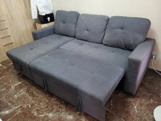Sofá cama gris  y mesa con mueble de comedor