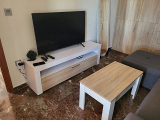Sofá cama gris  y mesa con mueble de comedor