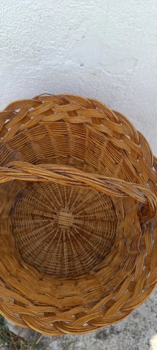 Cesta redonda de mimbre antigua con asa arqueada