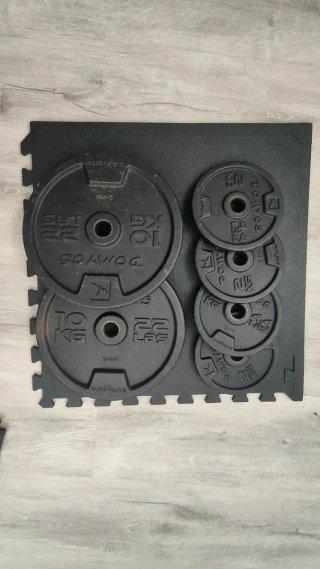 Banco de musculación con discos y mancuernas