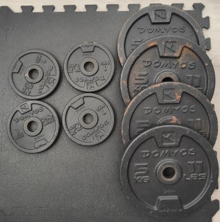 Banco de musculación con discos y mancuernas