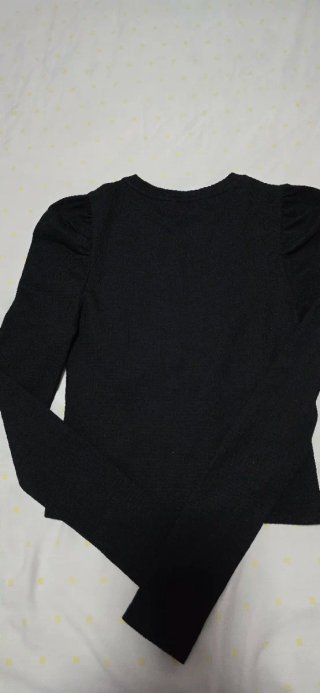 Sueter negro con hombro fruncido.