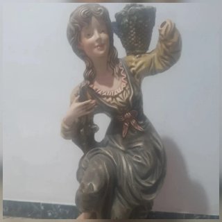 Escultura de mujer con cesta de frutas
