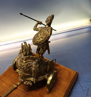 Escultura en bronce, Gladiador, guerrero romano en viga. Carro tirado por dos caballos.