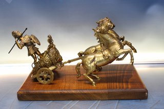 Escultura en bronce, Gladiador, guerrero romano en viga. Carro tirado por dos caballos.