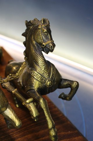 Escultura en bronce, Gladiador, guerrero romano en viga. Carro tirado por dos caballos.