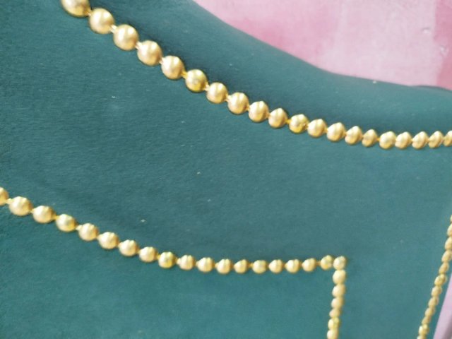Cabecero tapizado verde con tachuelas doradas