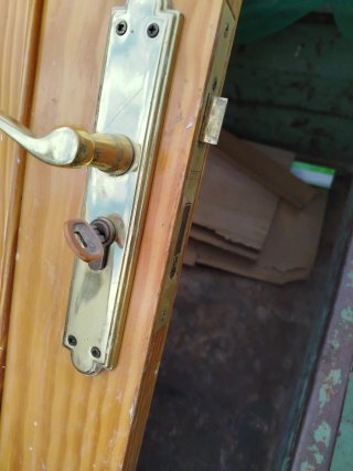 Puerta de madera con manilla dorada
