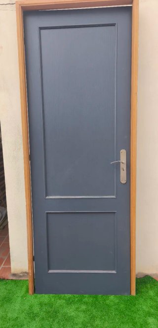 Puerta interior gris con marco de madera