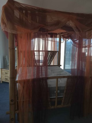 Cama con dosel de bambú y mimbre