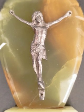 Cristo de metal sobre base mármol.