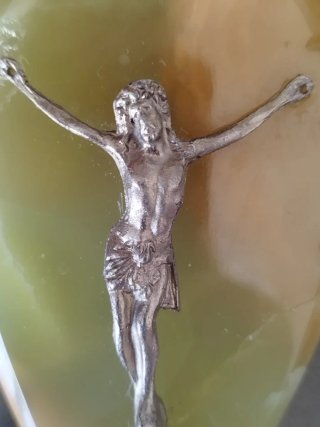 Cristo de metal sobre base mármol.