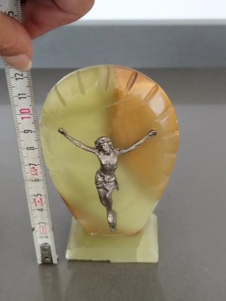 Cristo de metal sobre base mármol.