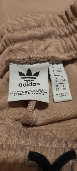 Pantaloni sportivi Adidas beige e nero.