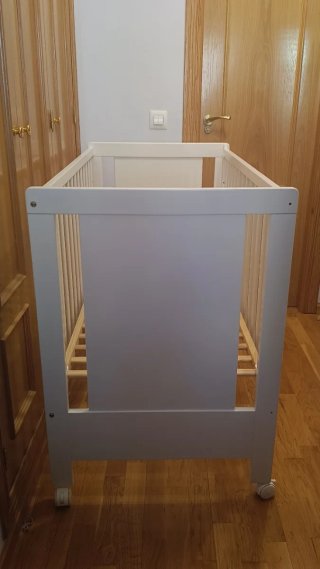 Cuna de madera blanca con ruedas