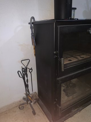 Estufa de leña negra con puertas de cristal