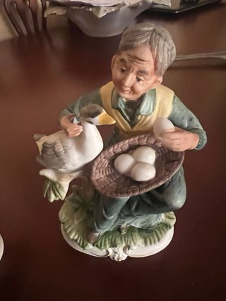 Coppia di figure decorative di anziani con uccelli