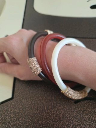 3 bracciali rigidi con dettagli dorati