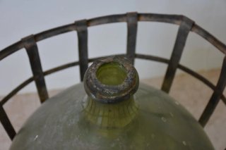 Antigua damajuana con cesta de hierro