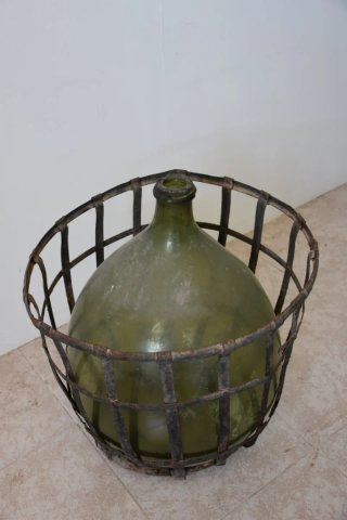 Antigua damajuana con cesta de hierro