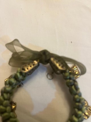 Pulsera verde con dijes de perritos dorados