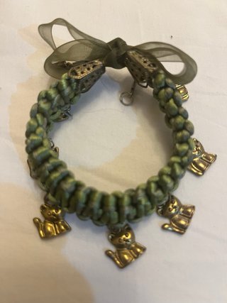 Pulsera verde con dijes de perritos dorados