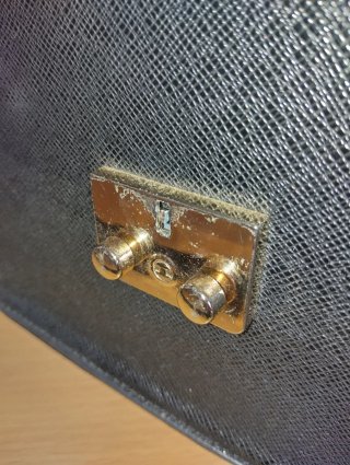 Borsa nera rigida con chiusura dorata