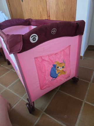 Cuna de viaje plegable rosa con dos alturas.