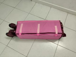 Cuna de viaje plegable rosa con dos alturas.