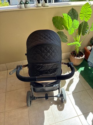Carrito de bebé negro con detalles dorados