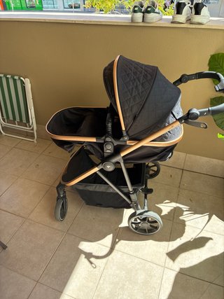 Carrito de bebé negro con detalles dorados