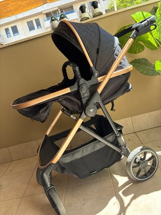 Carrito de bebé negro con detalles dorados