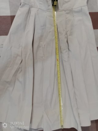 Vestido beige sin mangas con falda plisada