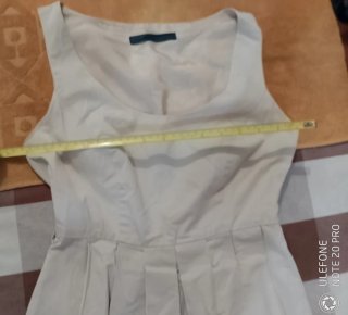 Vestido beige sin mangas con falda plisada