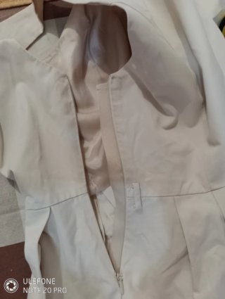 Vestido beige sin mangas con falda plisada