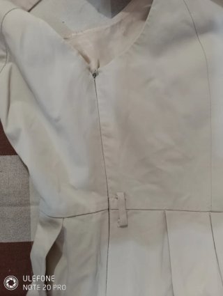 Vestido beige sin mangas con falda plisada