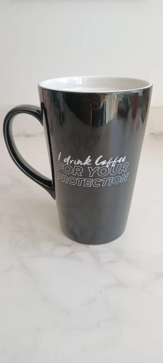 Taza negra con frase.