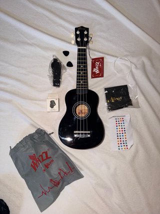 Ukelele negro con funda y accesorios