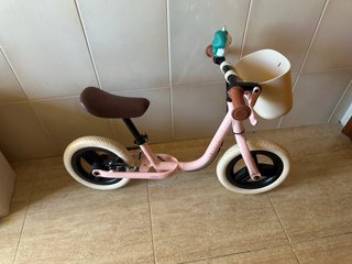 Bicicleta de equilibrio rosa con cesta