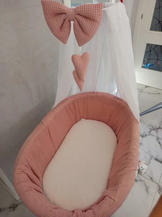Cuna de mimbre con dosel rosa